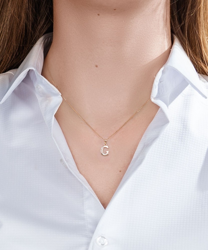 Gold pendant with zircons Letter G