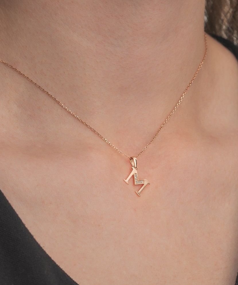 Gold pendant with zircons Letter M