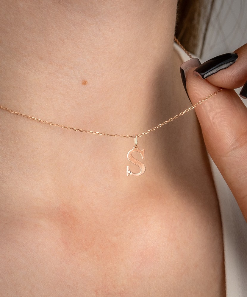 Gold pendant with diamond letter S
