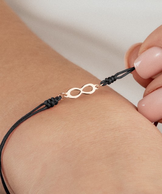 Black string bracelet with a gold pendant “Infinity”