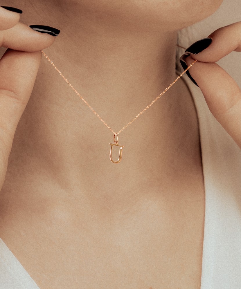 Gold pendant with diamond letter U