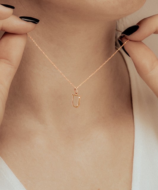 Gold pendant with diamond letter U
