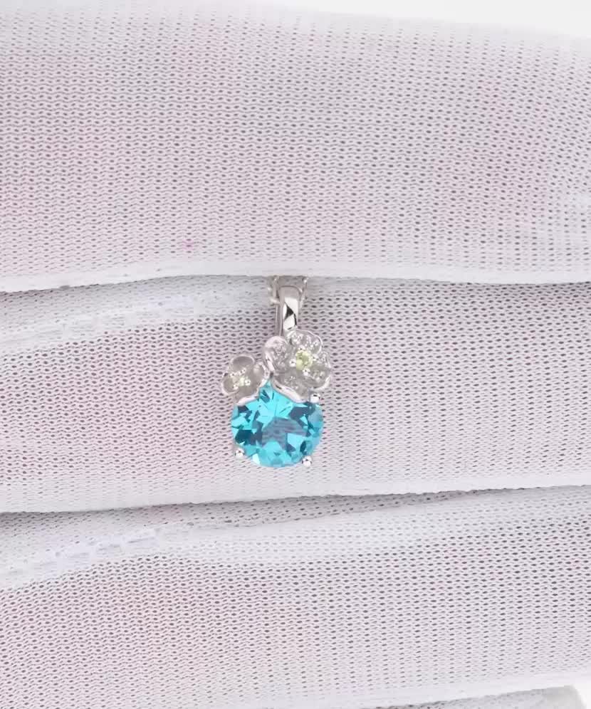 White gold pendant with topaz, diamonds and peridots