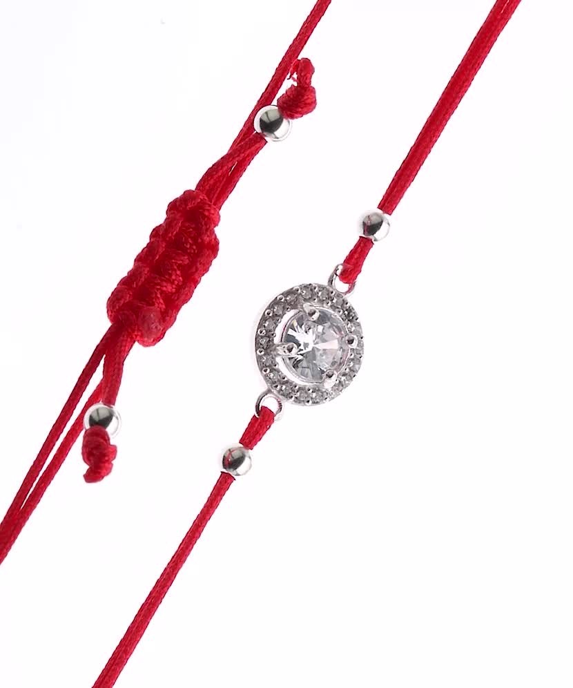 Браслет из красной нити с серебряной подвеской и цирконы